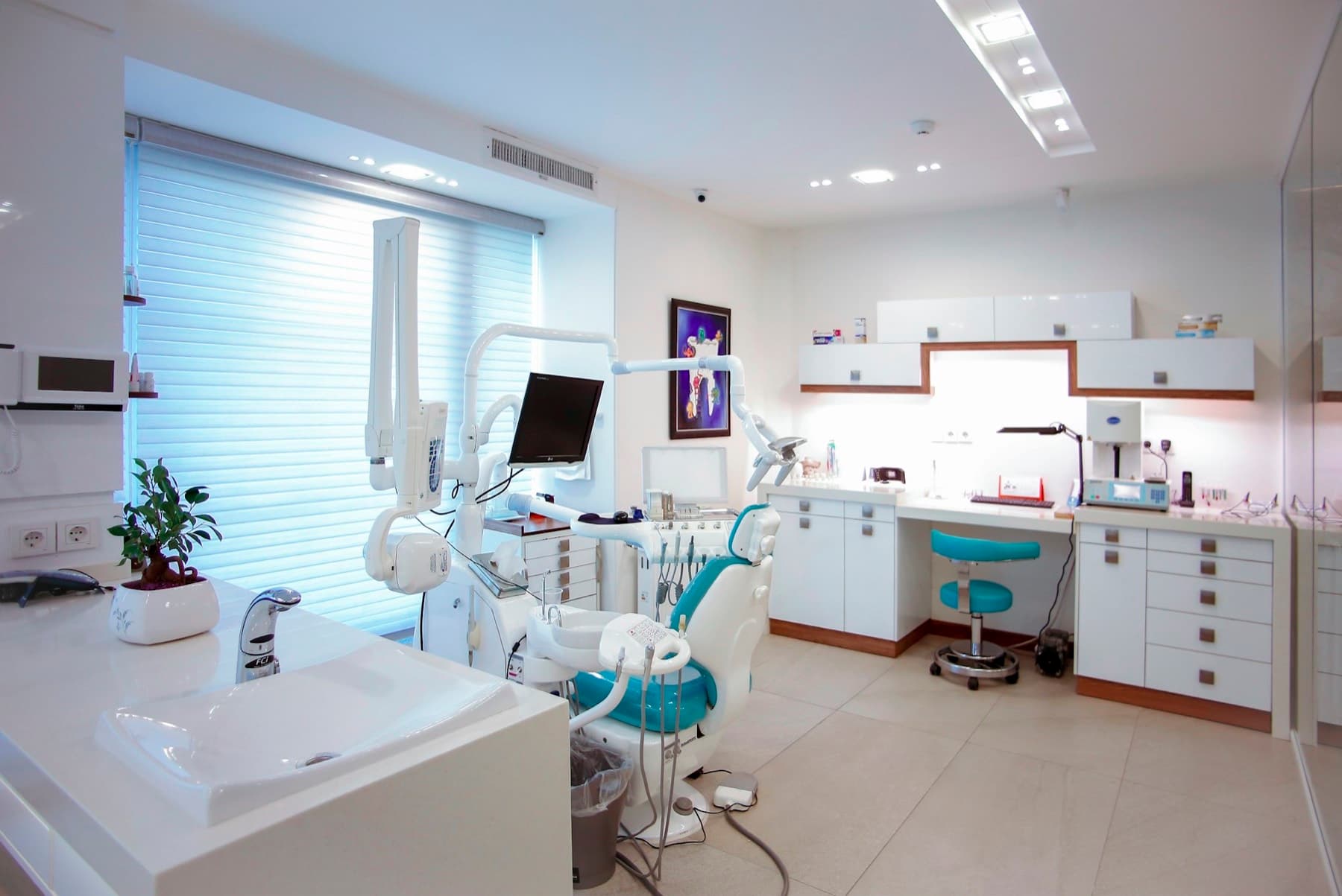 A bright treatment room with a dental chair by a large window